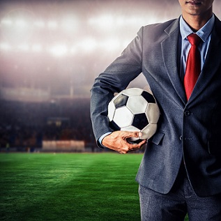 soccer manager holding football