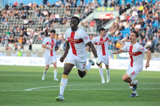 pisa genoa 2026 Ekhator esulta al gol del pareggio Canestrelli illude i nerazzurri, poi Ekhator e Colombo ribaltano la partita alla Cetilar Arena: Genoa concreto e maturo, Pisa sempre più solo sul fondo e con la Serie B alle porte. Pisa - Alla Cetilar Arena Garibaldi - stadio dal nome solenne e destino domenicale - si incontrano due delle quattro Repubbliche marinare, con i rossoblù che hanno il doppio dei punti dei padroni di casa. E il Genoa di Daniele De Rossi combina la sua piccola impresa operaia: va sotto, si scuote, risorge e alla fine passa a riscuotere due punti che odorano di salvezza quasi certificata. Il Pisa invece resta lì, impantanato sul fondo della classifica come barca senza remi nella nebbia di retrovia, in compagnia del Verona e con la Serie B che ormai gli soffia sul collo come vento freddo di tramontana. Hiljemark, privo di Marin e Denoon, si affida alla coppia Tramoni-Moreo, tandem generoso ma spesso costretto a predicare nel deserto. De Rossi invece presenta un Genoa rabberciato dagli acciacchi - senza Cornet, Norton-Cuffy, Ellertsson, Frendrup e Malinovskyi - ma con Baldanzi ed Ekhator a sostegno del giovane Colombo, mentre Vitinha resta in naftalina iniziale. Parte meglio il Grifone: Baldanzi si inventa una serpentina da ragazzo di strada del pallone e conclude di poco fuori, come a dire: siamo arrivati. Poi però, al minuto diciannove, il Pisa trova il vantaggio con un episodio da mischia medievale su corner di Angori: Canestrelli emerge dal groviglio come un corazziere e insacca di testa. È l’1-0 che accende per un attimo la speranza nerazzurra. Tre minuti più tardi lo stesso Angori, lanciato in contropiede con Tramoni al fianco come compagno di scorribanda, sceglie la gloria personale invece della geometria del passaggio: Bijlow, portiere di riflessi felini, salva di piede e cambia il destino della partita. Il Genoa ringrazia - e nel calcio chi ringrazia spesso incassa - perché al 41’ nasce il pareggio. Rimessa laterale avanzata, Colombo lavora la palla da centravanti vero, Baldanzi rifinisce con intelligenza da trequartista moderno e Ekhator scarica un sinistro rabbioso all’incrocio: gesto tecnico pulito, definitivo, quasi letterario. Prima dell’intervallo Colombo avrebbe anche la palla del sorpasso, ma la mira tradisce. Nella ripresa il Genoa completa la rimonta al 55’: mano di Canestrelli su conclusione di Baldanzi, rigore inevitabile. Colombo dal dischetto non trema e spiazza Semper con freddezza da professionista navigato. A quel punto i rossoblù arretrano il baricentro, si chiudono come ricci prudenti e lasciano al Pisa l’illusione dell’assedio. Aebischer prova a riaprire la storia con un diagonale insidioso, ma Bijlow risponde ancora presente con un intervento da portiere di categoria superiore. Poi la sfuriata toscana si spegne come brace senza legna. Il Genoa controlla, respira, resiste - e porta a casa tre punti d’oro massiccio. Quinta vittoria nelle ultime otto: numeri da squadra che ha imparato a salvarsi da sola. Il Pisa invece continua a incassare gol come pioggia d’autunno - sessanta ormai — e scivola lentamente verso la retrocessione, con passo triste e inevitabile. Una discesa silenziosa, quasi annunciata. (Alessandro Bugelli) IL TABELLINO
PISA-GENOA 1-2
Pisa (3-5-2): Semper 6; Calabresi 5,5 (16' st Vural 6), Caracciolo 6, Canestrelli 6; Touré 5,5 (25' st Piccinini 6), Loyola 5,5 (11' st Meister 5,5), Aebischer 5,5, Akinsanmiro 5,5 (16' st Cuadrado 6), Angori 6; Moreo 5,5, Tramoni 5,5 (25' st Durosinmi 6). A disp.: Nicolas, Scuffet, Bozhinov, Højholt, Stengs, Coppola, Albiol, Stojilkovic. All.: Hjulmand 5,5 Genoa (3-4-2-1): Bijlow 6,5; Marcandalli 6, Ostigård 5,5, Vasquez 6; Martin 6, Amorim 6 (33' st Vitinha 6), Masini 6,5, Sabelli 6 (42' st Otoa sv); Baldanzi 7 (21' st Messias 6), Ekhator 7 (20' st Onana 6); Colombo 7 (34' st Ekuban 6). A disp.: Leali, Sommariva, Zätterström, Lafont, Grossi, Ouedraogo. All.: De Rossi 7 Arbitro: Crezzini
Marcatori: 19' Canestrelli (P), 41' Ekhator (G), 10' st rig. Colombo (G)
Ammoniti: Calabresi (P), Ostigard (G), Aebischer (P), Caracciolo (P)